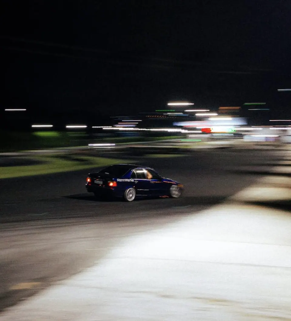 E36 azul da RennWerke de lado na pista à noite