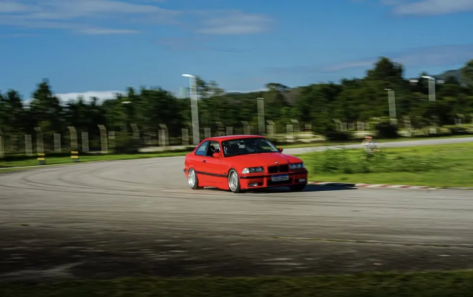 E36 coupé vermelha contornando curva na pista